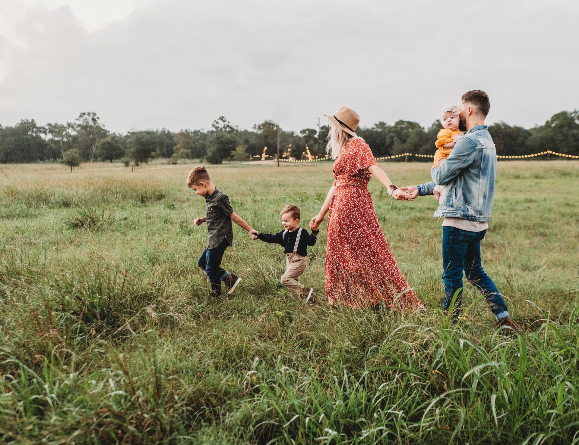 A mother walking through a field with her children